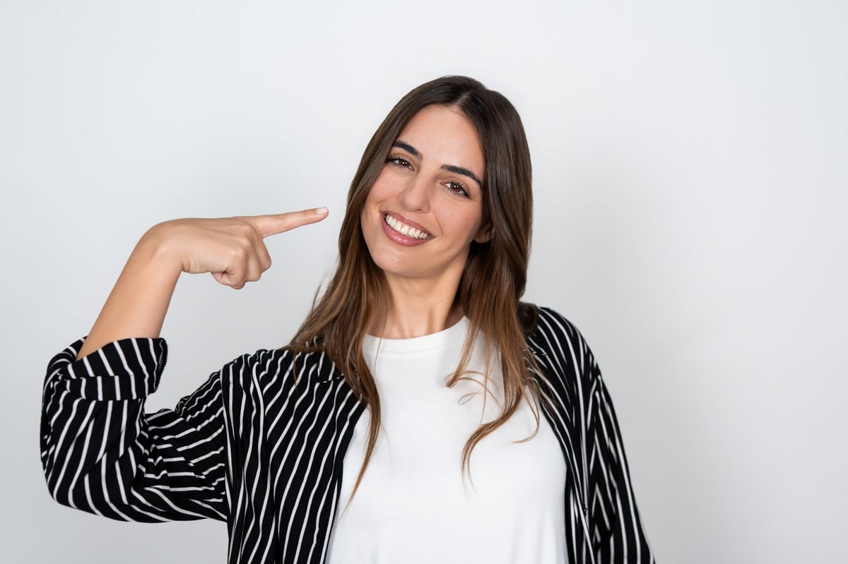 Woman smiling while holding a whitening strip